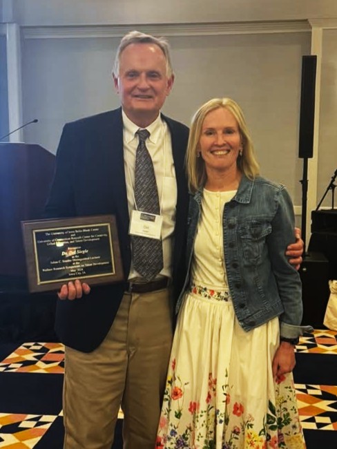 Del Siegle receiving Julian Stanley Distinguished Lecture plaque from Megan Foley-Nicpon at Wallace Symposium on Talent Development at the University of Iowa